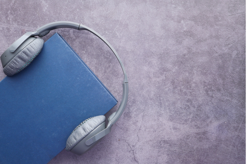 un livre bleu portant des écouteurs.