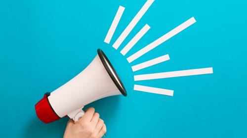 Une main tient un mégaphone.