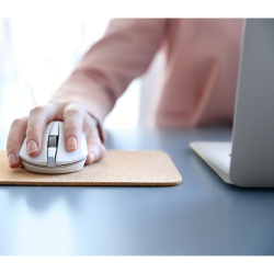 Gros plan d'une personne utilisant un ordinateur portable avec la main sur une souris d'ordinateur.